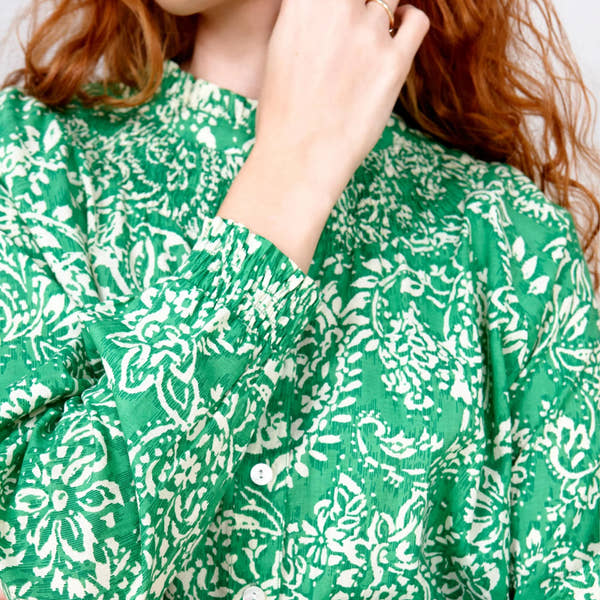 close up of woman in green and white paisley blouse